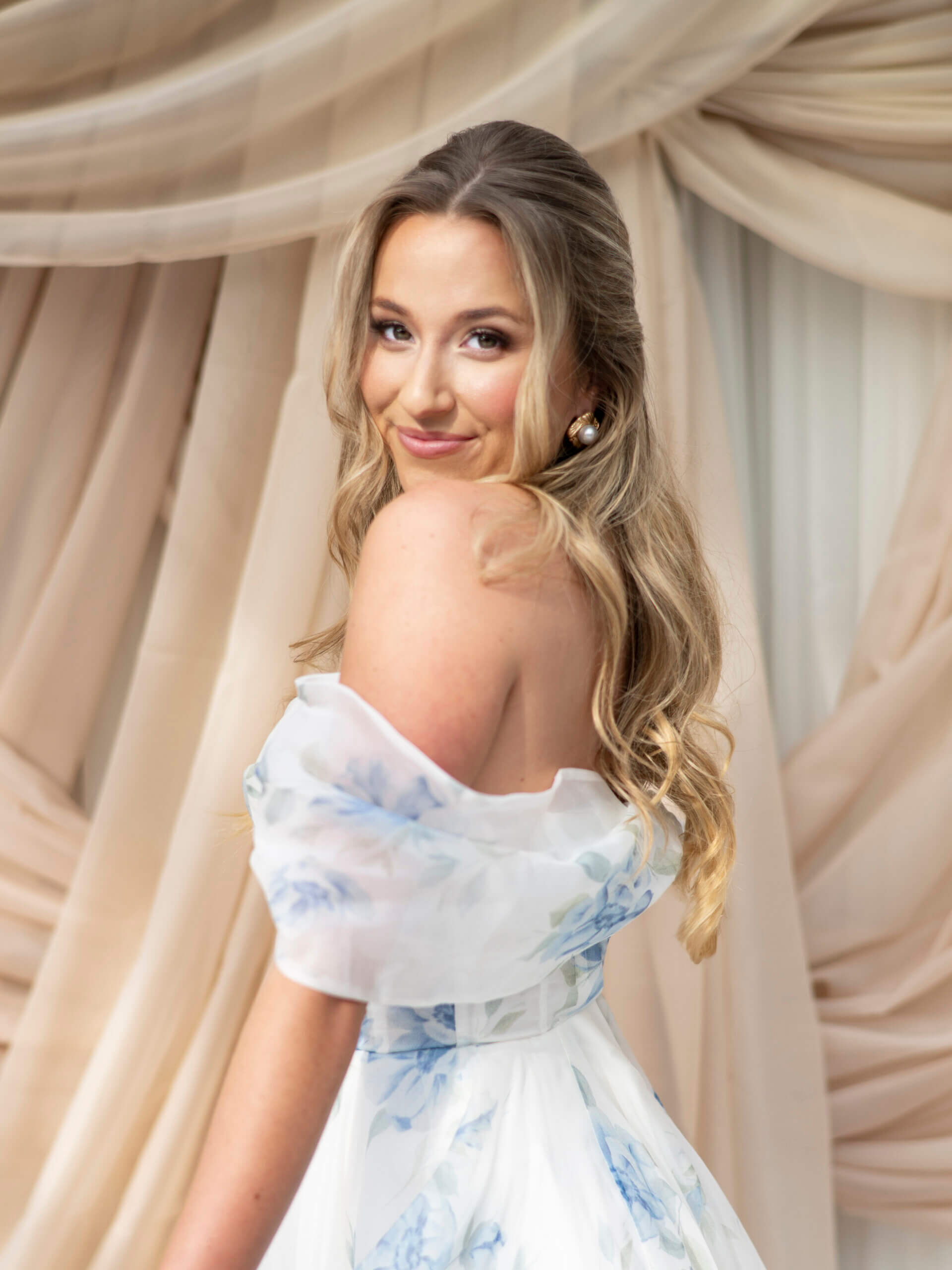 A side view of a medium-length wavy hairstyle held in place by two pearl-adorned hairclips