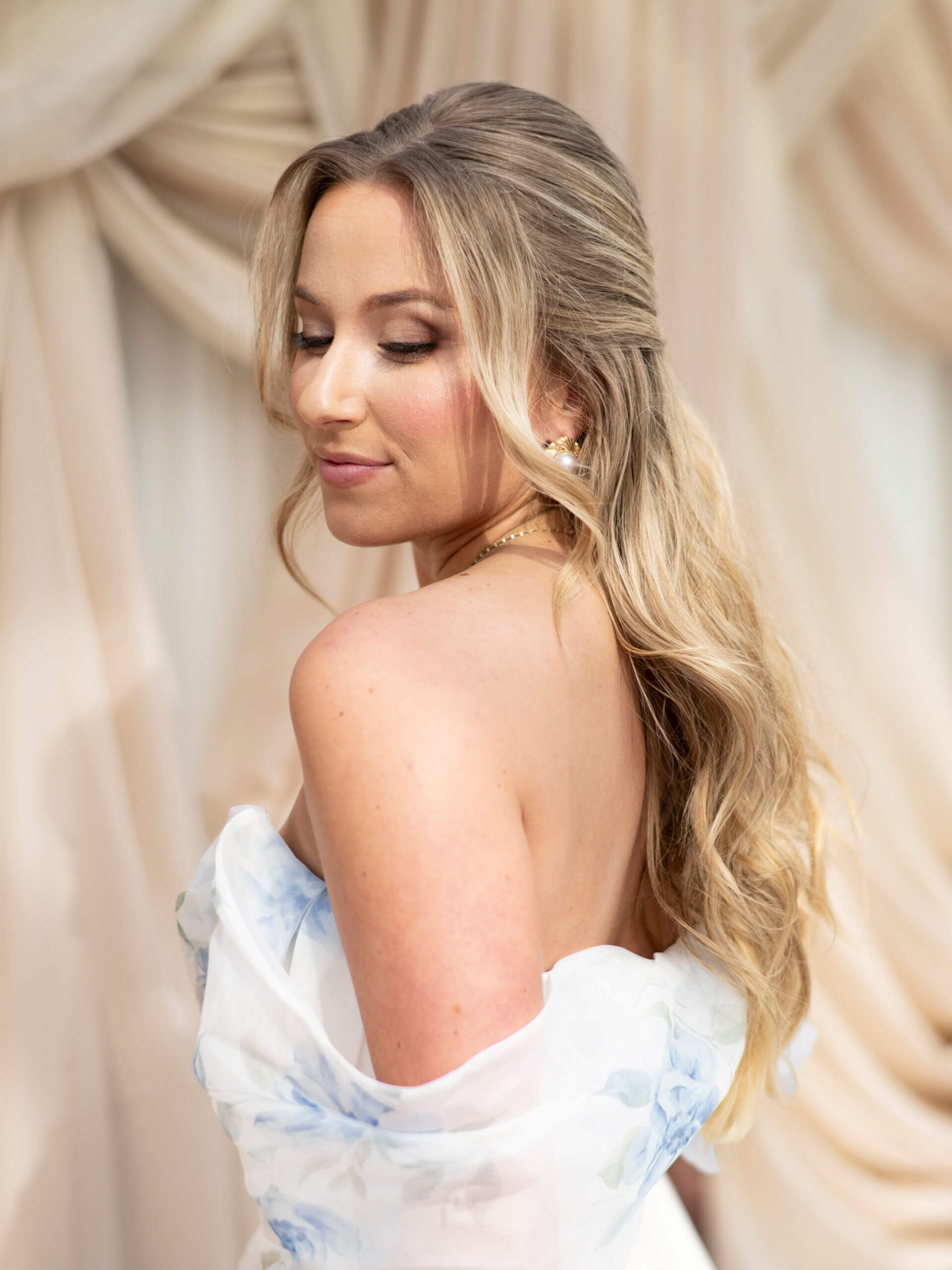 A three-quarters view of a medium-length wavy hairstyle held in place by two pearl-adorned hairclips